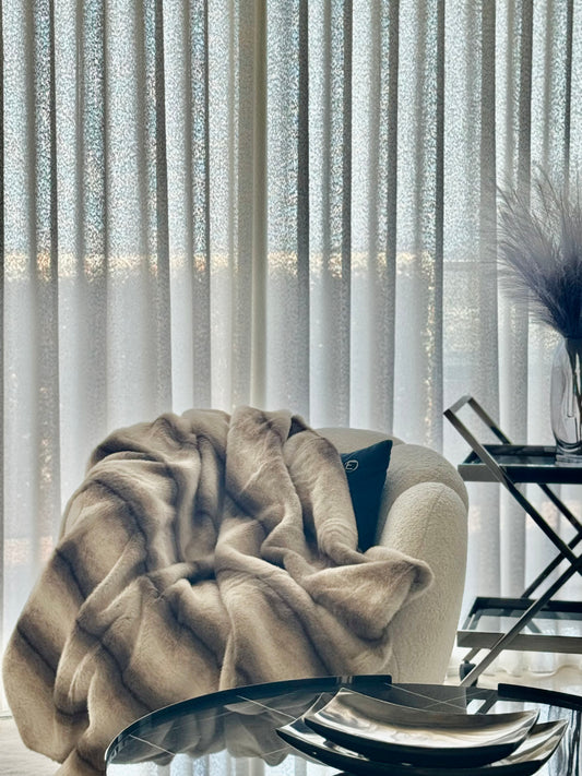 Gros plan texture douce fausse fourrure crème beige montrant la qualité moelleuse du plaid